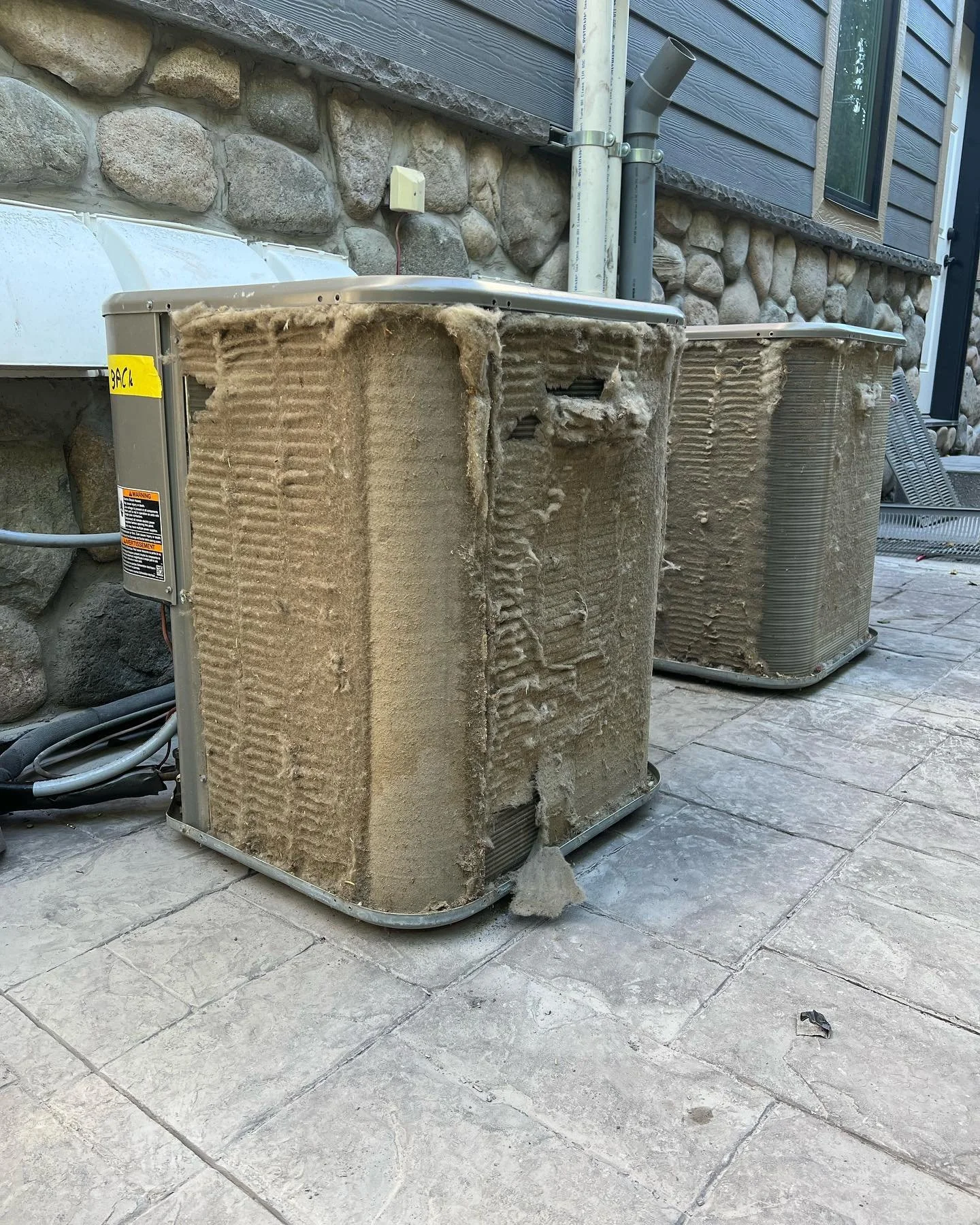 Exterior condenser units blocked with debris before service